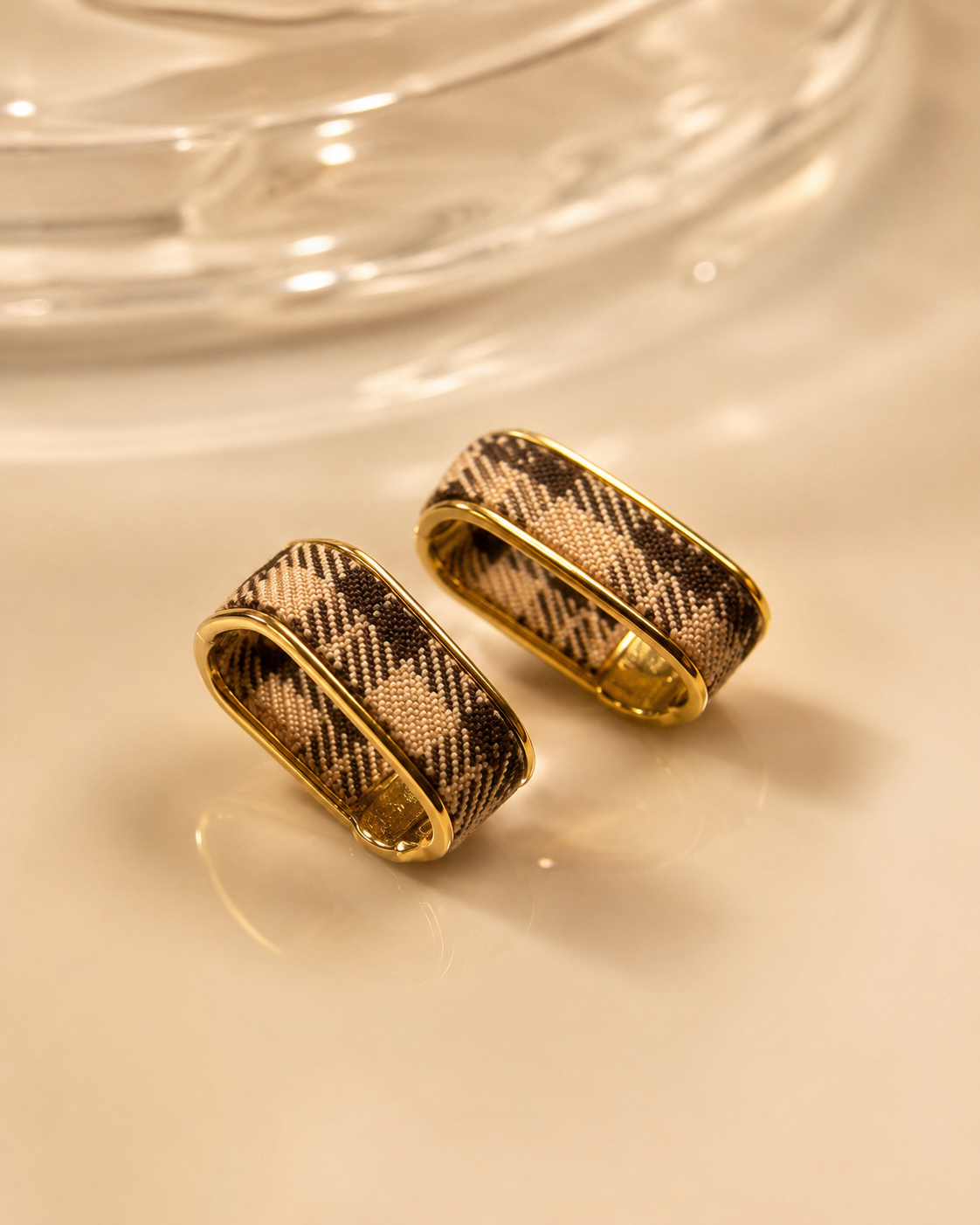 Check Luxe gold-tone wide hoop earrings with woven check pattern photographed in warm golden light