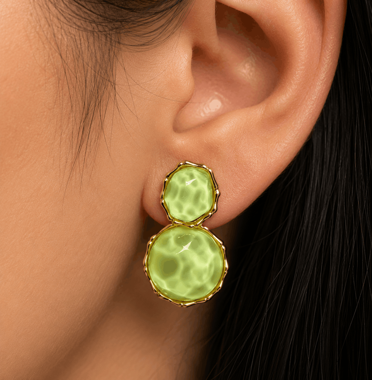 Verdant Muse gold-tone earrings with green resin stones worn by a model