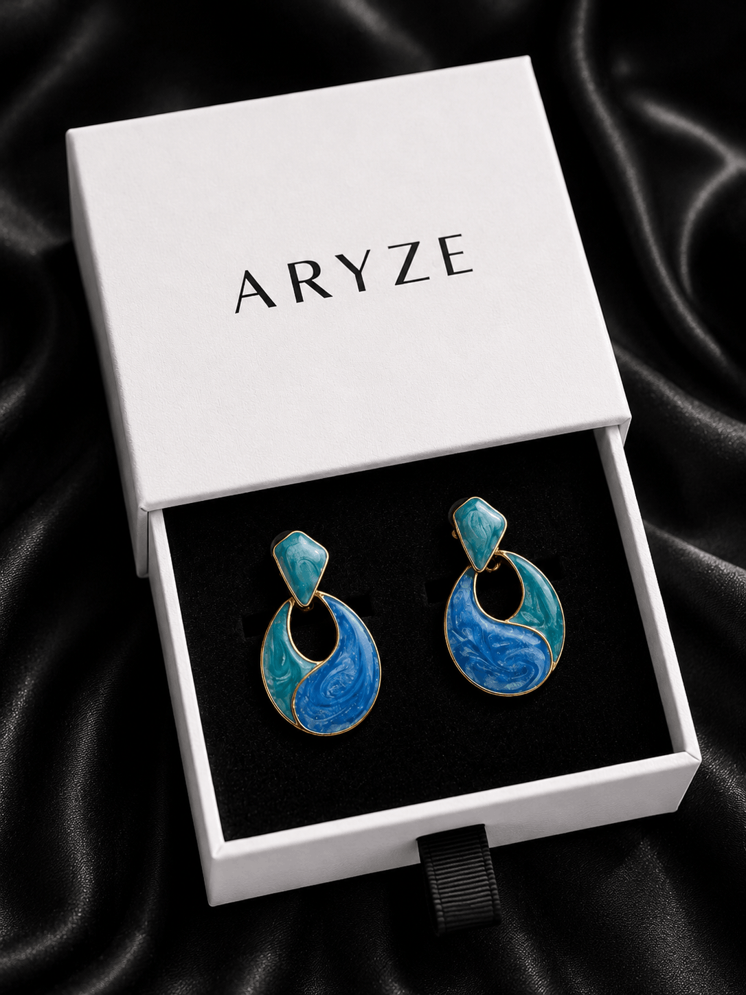 Ocean Muse gold-tone statement earrings with blue and teal enamel presented in the branded Aryze gift box
